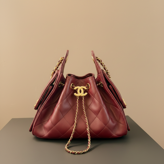 A red quilted leather handbag with gold-tone hardware, including a prominent interlocking CC logo on the front, resting on a dark surface with a Chanel box partially visible in the background.